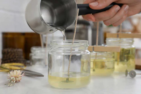 Premium Photo  Homemade candle making session using soy wax and assorted  glass containers photo shows a pair of hands using a thermometer to check  the temperature of soy wax