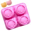 Finished cat head shaped desserts and baked bread next to the pink silicone crafting mold