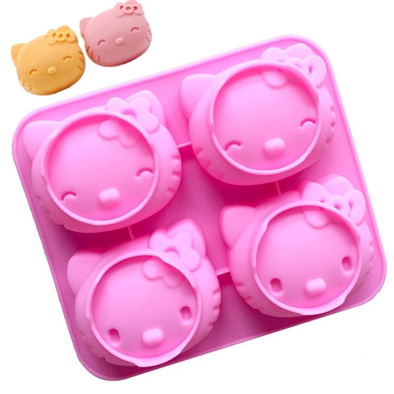 Finished cat head shaped desserts and baked bread next to the pink silicone crafting mold